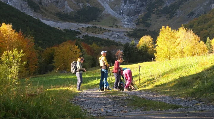 Trainertour 2025 Bild 1 | © DAV-FN / I. Eichenberg Wanderer mit Rucksäcken auf einem Weg in herbstlicher Berglandschaft mit bunten Bäumen und Felsen im Hintergrund. | © DAV-FN / I. Eichenberg
