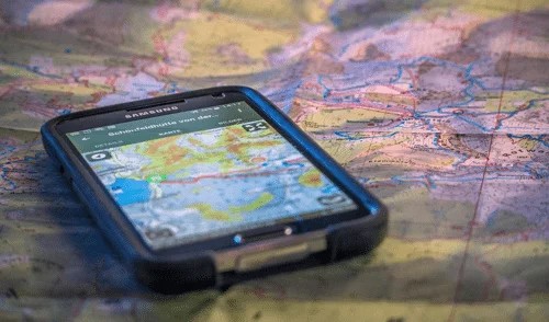 alpenvereinactive Outdoor-App | © DAV Ein Navigationsgerät liegt auf einer Landkarte | © DAV