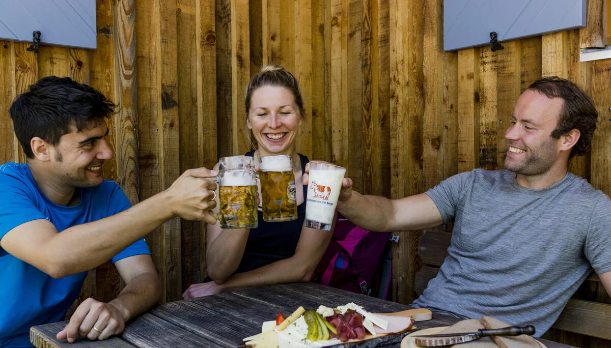 Prost auf der Berghütte | © DAV/Hans Herbig Auf der Hütte: Drei Personen stoßen mit Bierkrügen an | © DAV/Hans Herbig